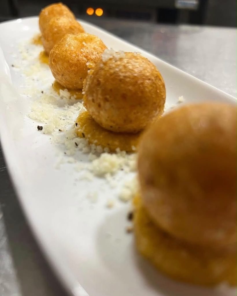 Croquetas caseras de cacio e pepe sobre crema de carbonara