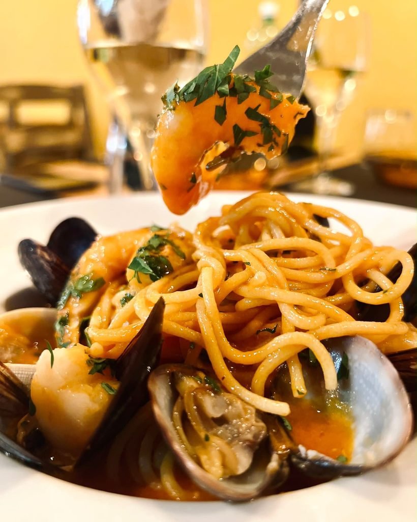 Spaghetto allo scoglio con mejillones, almejas y gambas, servido en la mesa