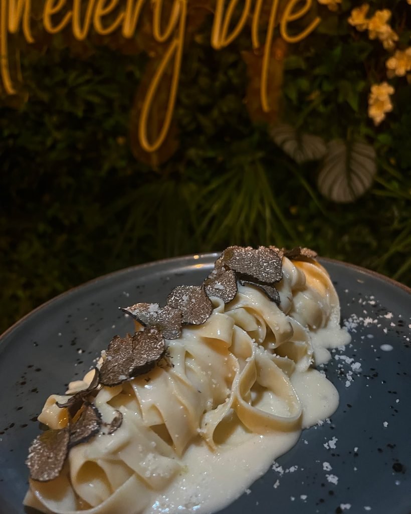 Tagliatelle al tartufo bajo el neón de la sala