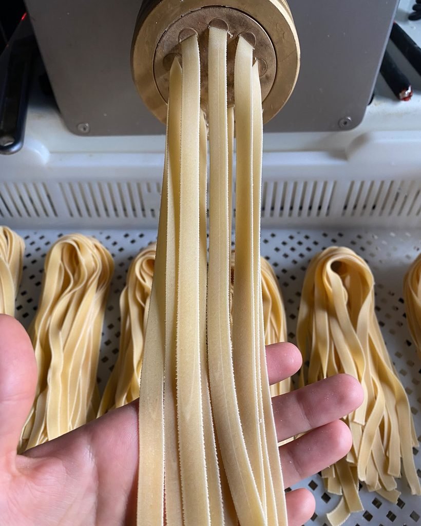 Tagliolini saliendo de la máquina de pasta
